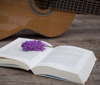 libro aperto con fiori di lavanda e una chitarra
